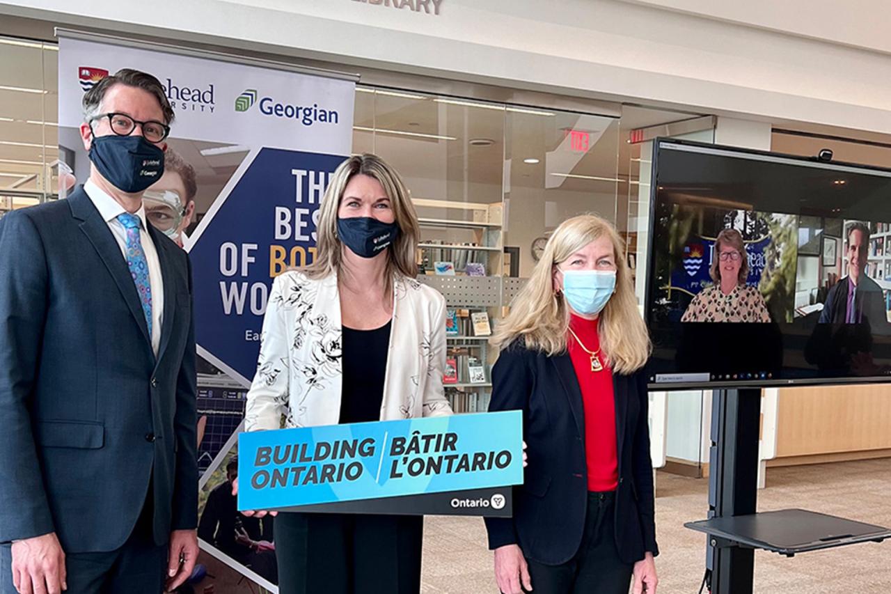 Mike Den Haan, Jill Dunlop and Angela Lockridge stand in the Orsi Family Learning Commons