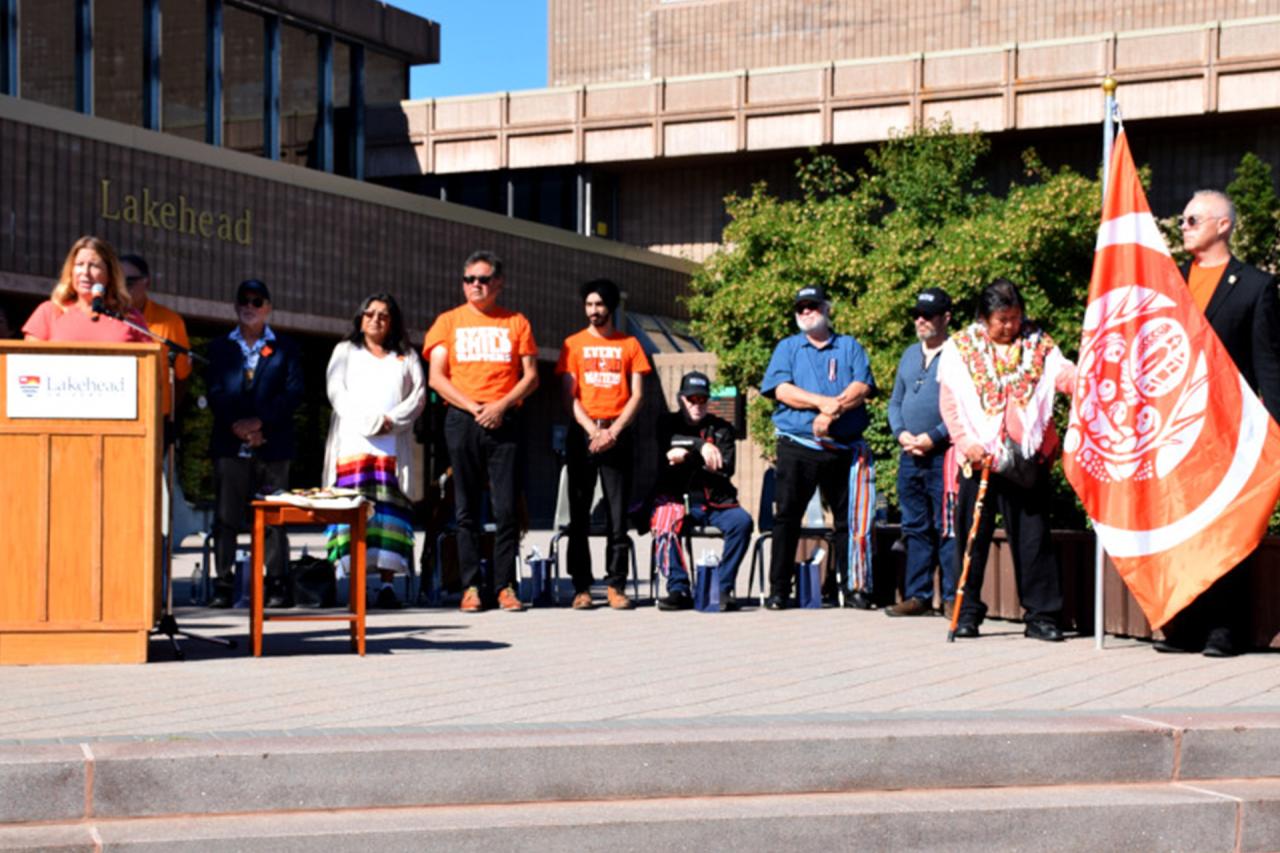 Honorary Survivor, Elder Catherine McGuire, far right, raised the flag designed by Residential School Survivors and the National Centre for Truth and Reconciliation, which will be on display in the Agora for the month of September.