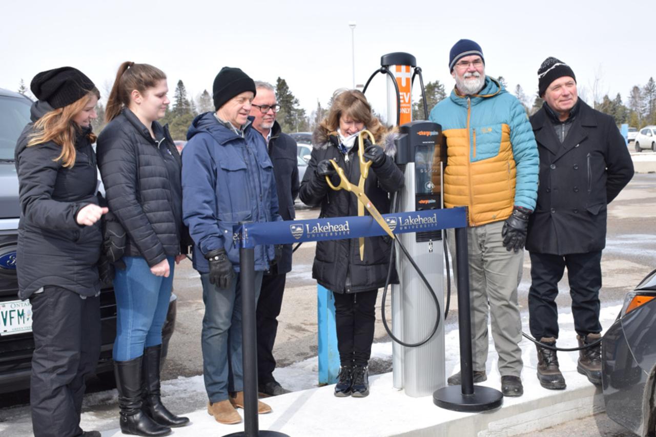 Dr. Moira McPherson, Lakehead's President and Vice-Chancellor, third from right, cut the ribbon to celebrate the grand opening of electric vehicle charging stations now available at the Thunder Bay campus. Also participating from left to right, are Devon Lee, Lakehead's Sustainability Coordinator; Kirsten Kabernick, Project Coordinator with the CEDC; Dr. Andrew P. Dean, Lakehead's Vice-President, Research and Innovation; Dr. David Barnett, Lakehead's Provost and Vice-President (Academic); Hugh Briggs, Direc